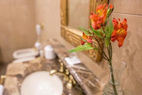 a vase of flowers sitting on a counter in a bathroom at Claridge Hotel in Buenos Aires