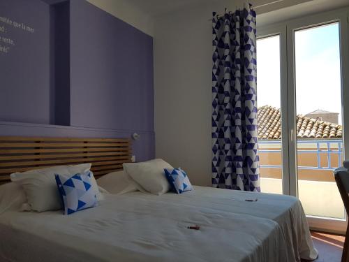 a bedroom with two beds and a large window at Villa TerraMera Hôtel in Le Lavandou