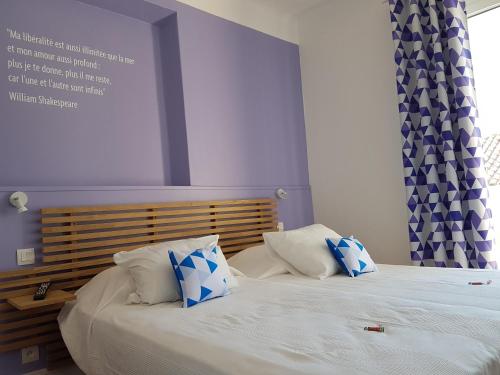 a bedroom with two beds with blue and white pillows at Villa TerraMera Hôtel in Le Lavandou