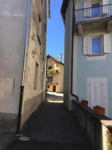 an alley between two white buildings with a balcony at Cà Dela in Moghegno