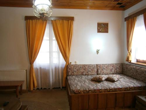 a living room with a couch in a room with windows at Filira in Vitsa