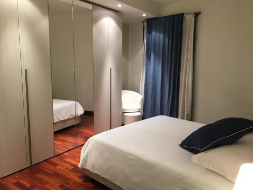 a bedroom with a white bed and a mirror at IN PIAZZA appartamento con vista in Lazise