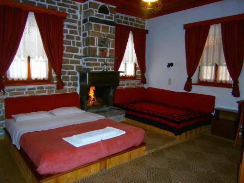 a bedroom with a fireplace and a bed and a couch at Filira in Vitsa