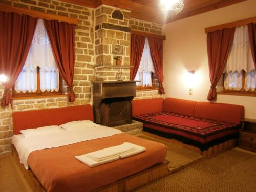 a bedroom with a bed and a couch and a fireplace at Filira in Vitsa