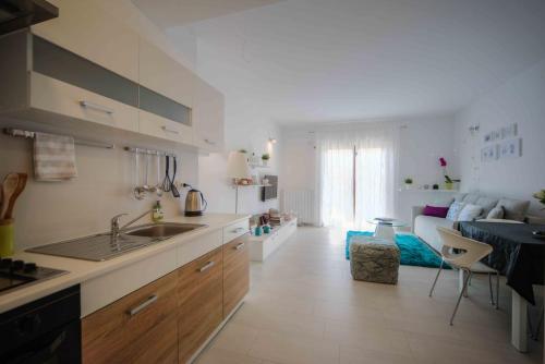 eine Küche mit einem Waschbecken und ein Wohnzimmer in der Unterkunft Apartment Aleksandra in Pula