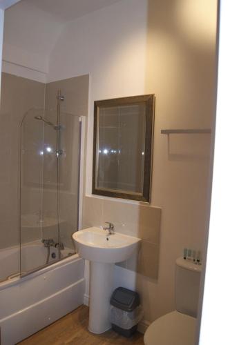 a bathroom with a sink and a shower and a toilet at Kings Hotel in Newmarket