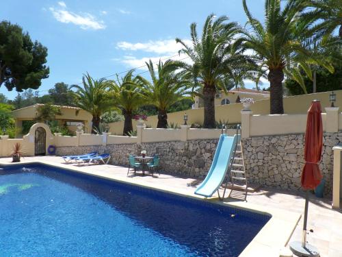a swimming pool with a slide next to a resort at Villa Senomar in Benissa