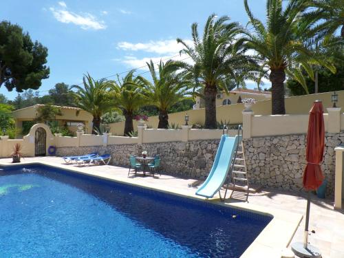 una piscina con un tobogán junto a un complejo en Villa Senomar, en Benissa