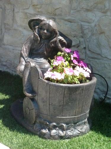 a statue of a bunny sitting in a pot of flowers at Albergo Casa Este in Brenzone sul Garda