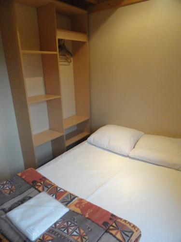 Kleines Zimmer mit 2 Betten und Regalen in der Unterkunft Les Chalets De Mur De Sologne in Mur-de-Sologne