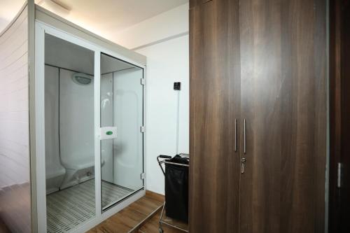 a bathroom with a mirror and a wooden cabinet at Bidwood Suite Hotel in Nairobi