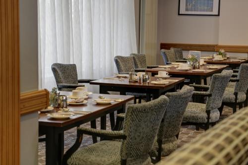 a dining room with long tables and chairs with plates and dishes at Best Western Kings Manor in Edinburgh