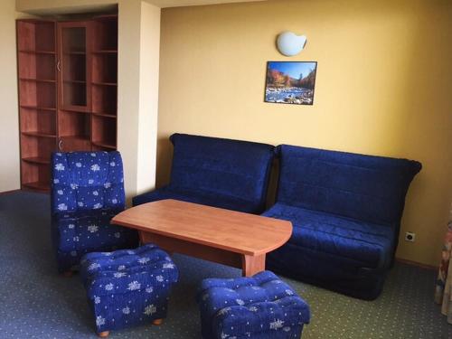a living room with a blue couch and a table at Hotel Jambo in Golden Sands
