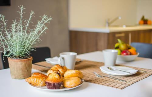 a table with a plate of pastries on a table at Aparthotel Nelva Resort in Cala'n Porter