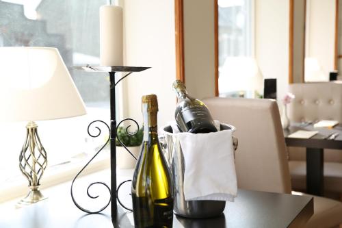 a table with two bottles of wine in a vase at Keswick Park Hotel in Keswick