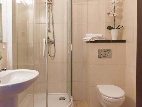 a bathroom with a shower and a toilet and a sink at VacationClub - Regina Maris Apartment 71 in Świnoujście