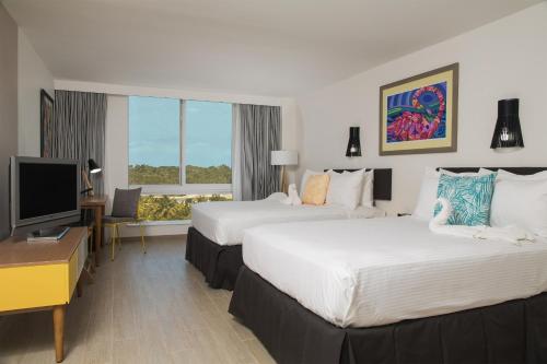 a hotel room with two beds and a flat screen tv at Warwick Paradise Island Bahamas - All Inclusive - Adults Only in Nassau