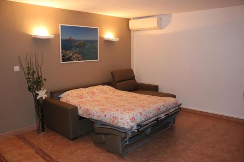 ein Krankenhauszimmer mit einem Bett und einem Stuhl in der Unterkunft Coeur de Fréjus, L'AMPHITHÉÂTRE, appartement 3 pièces climatisé, terrasse, barbecue, piscine & parking in Fréjus
