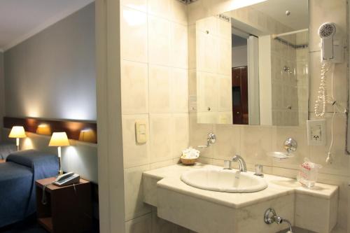 a bathroom with a sink and a mirror at Hotel Libertador in Santiago del Estero