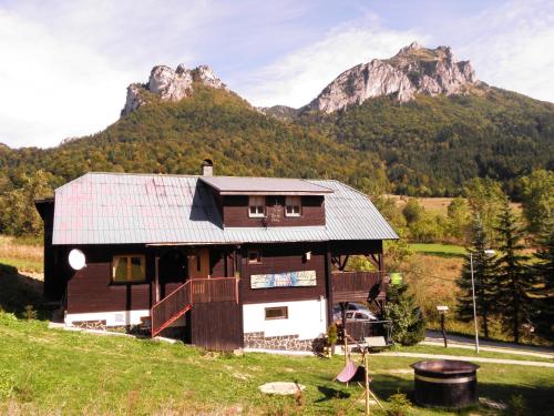 a small house with a mountain in the background at Penzion Muran in Terchová