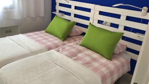 1 dormitorio con 2 camas y almohadas verdes en Rosa Nautica 301, en La Herradura