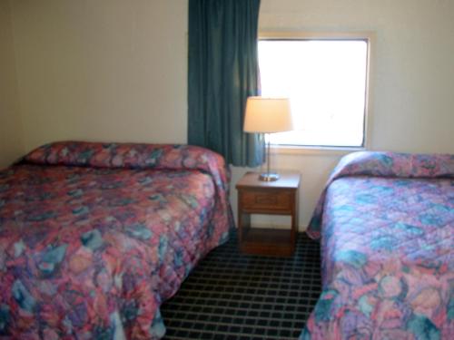 a hotel room with two beds and a window at Cerca Del Mar Motel in Virginia Beach