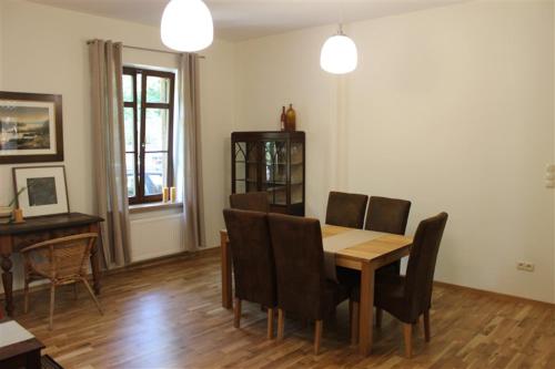 una sala da pranzo con tavolo e sedie in legno di Willa Widok - Apartament Naleczow a Nałęczów