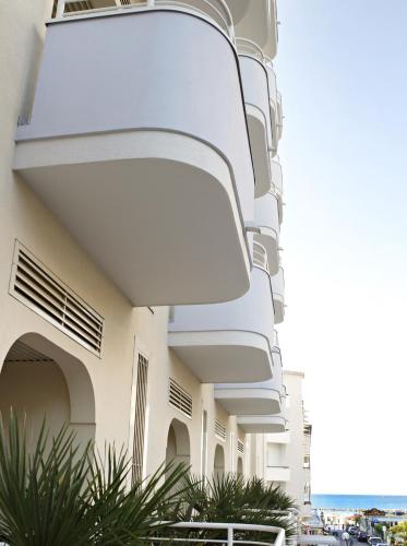 a facade of a building with balconies and plants at Mediterraneo Hotel & Suites in Cattolica