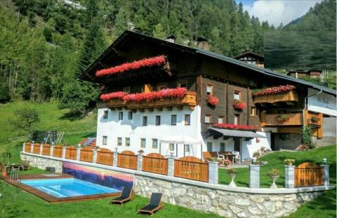 a house with a swimming pool in front of it at Haus Benedikt in Heiligenblut