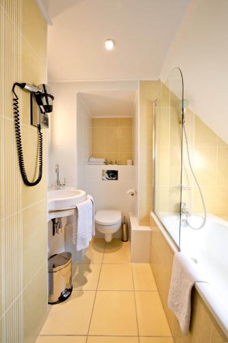 une salle de bain avec toilettes, lavabo et douche dans l'établissement Berkeley, à Paris