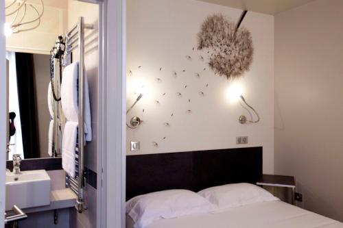 a bedroom with a bed and a sink and a mirror at Hotel Vivaldi in Puteaux