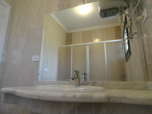 a bathroom with a sink with a mirror and a sink at Villa at Karawan Resort in Al Ḩammām