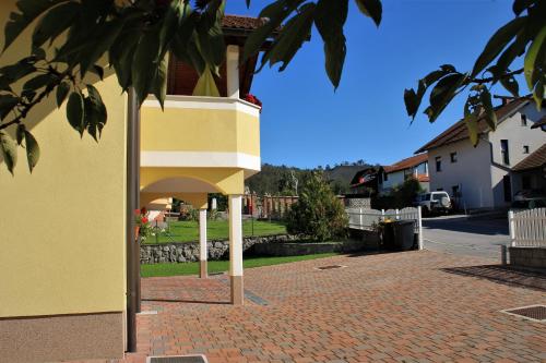 a yellow building with a brick walkway next to a house at Yellow Dreamhouse in Postojna