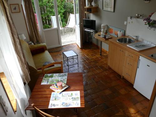 a kitchen with a table and a kitchen with a sink at Gîte Sourdeval in Sourdeval