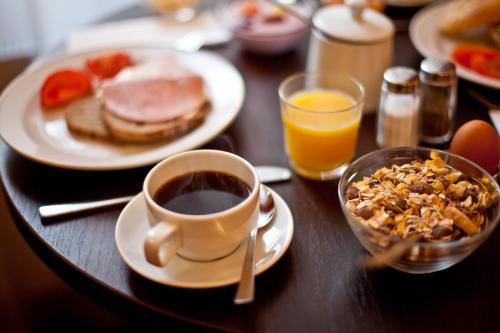a table with a cup of coffee and a plate of breakfast food at Hotel Polo am ZOB in Hamburg