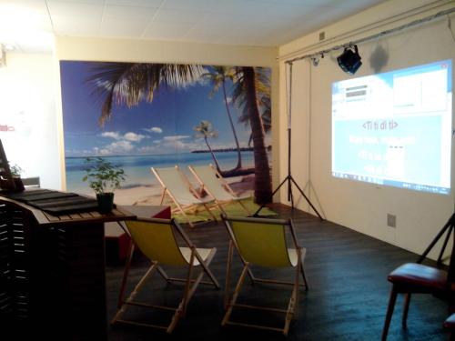 une salle de réunion avec écran et présentation dans l'établissement Centre Familial de Vacances Les Sylvageois, à Les Sauvages