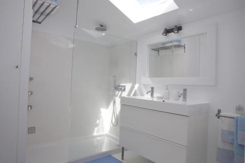 a white bathroom with a sink and a mirror at Casa Ana in Tavira