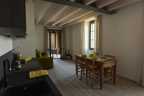 a kitchen and living room with a table and chairs at Cascina Varini in Gargnano