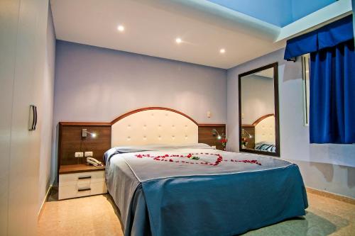 een slaapkamer met een groot bed en een spiegel bij Kitewind Apartamentos Cabarete in Cabarete