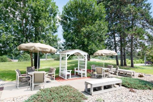 a patio with tables and chairs and umbrellas at Super 8 by Wyndham Sparta in Sparta
