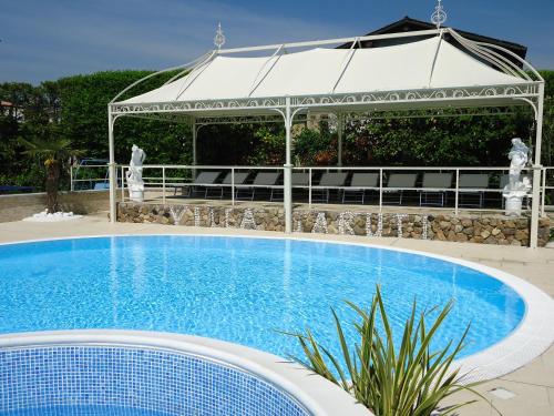 una grande piscina con gazebo sullo sfondo di Hotel Villa Garuti a Padenghe sul Garda