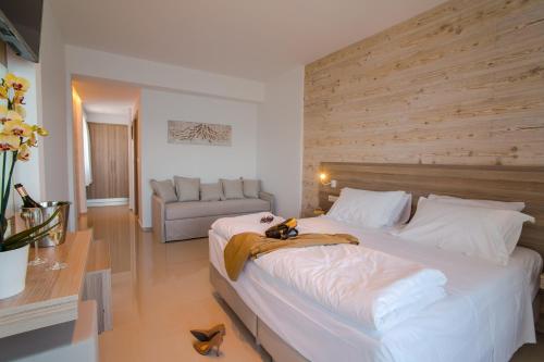 a bedroom with a large white bed and a couch at Orpheus Studios in Kos Town