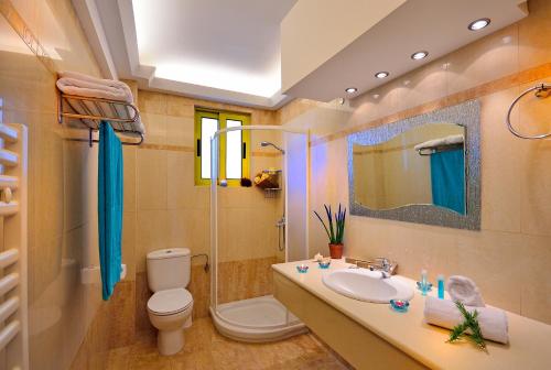 een badkamer met een wastafel, een toilet en een spiegel bij 12 Islands Villas in Kolimbia
