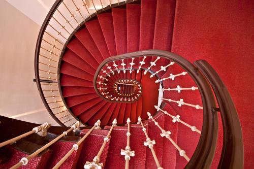 a red spiral staircase with a red wall at Hotel Polo am ZOB in Hamburg
