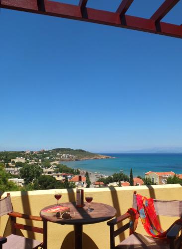 a table on a balcony with a view of the ocean at Aeriko Benovias Rooms & Apartments in Karfas