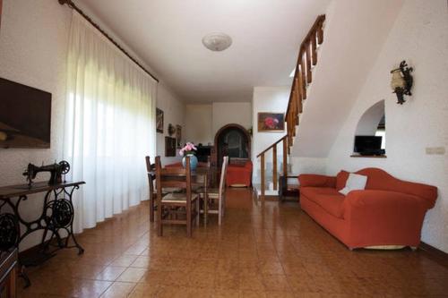 uma sala de estar com um sofá vermelho e uma mesa em Casale Bambù - Hidden Countryhouse em Rocca Massima