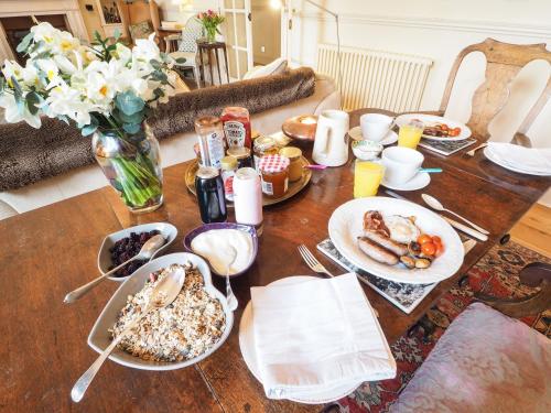Una mesa de madera con platos de comida encima. en The Clock Tower, en Daventry