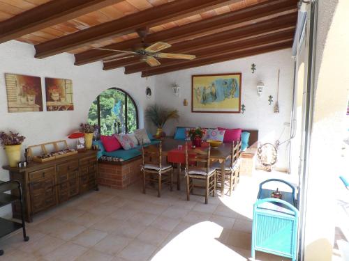 a patio with a table and chairs and a ceiling fan at Villa Senomar in Benissa