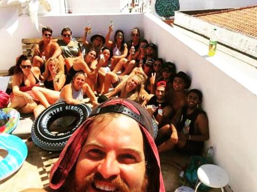 a large group of people sitting on a beach at The 17 Hostel in Lagos