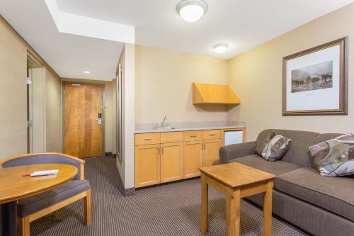 - un salon avec un canapé et une table dans l'établissement Canmore Inn & Suites, à Canmore
